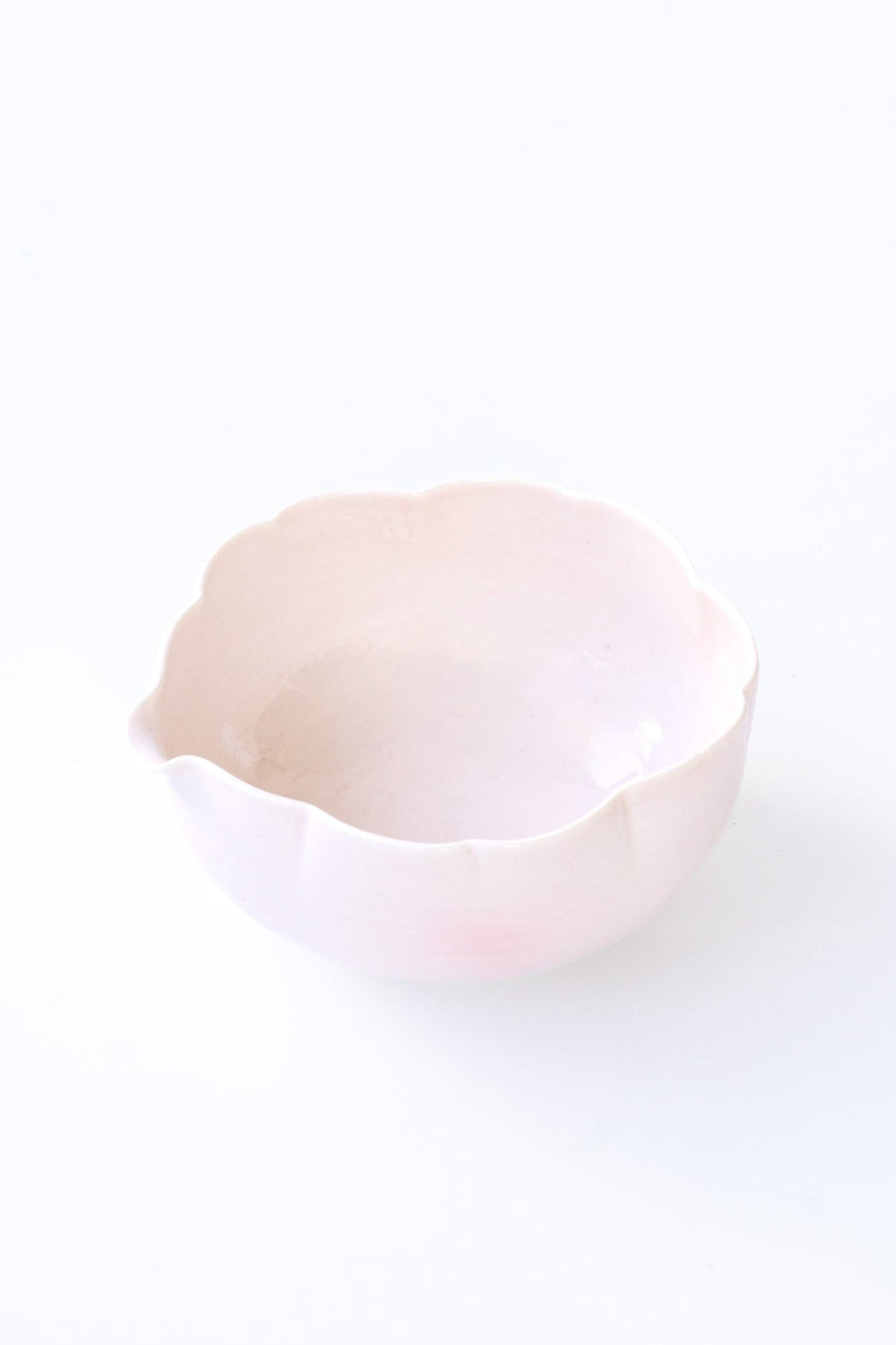 Pink flower shaped ceramic matcha bowl on a white background