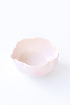 Pink flower shaped ceramic matcha bowl on a white background